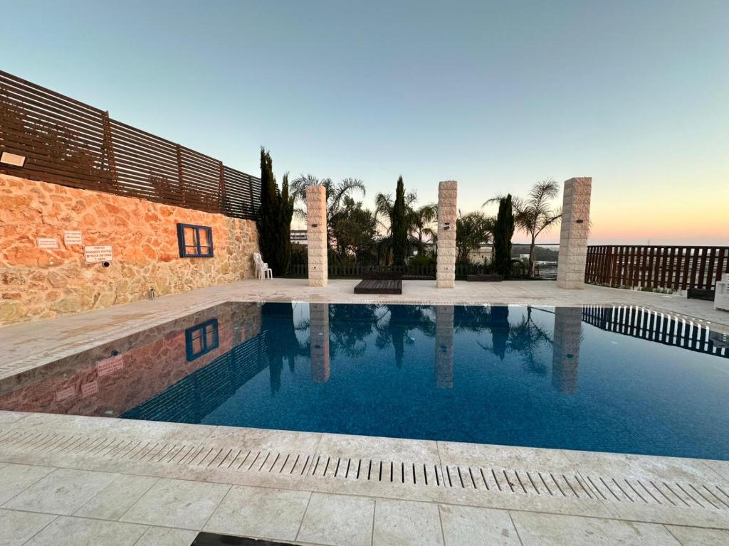 a swimming pool in front of a building at carmel cabins suite 12 in Yājur