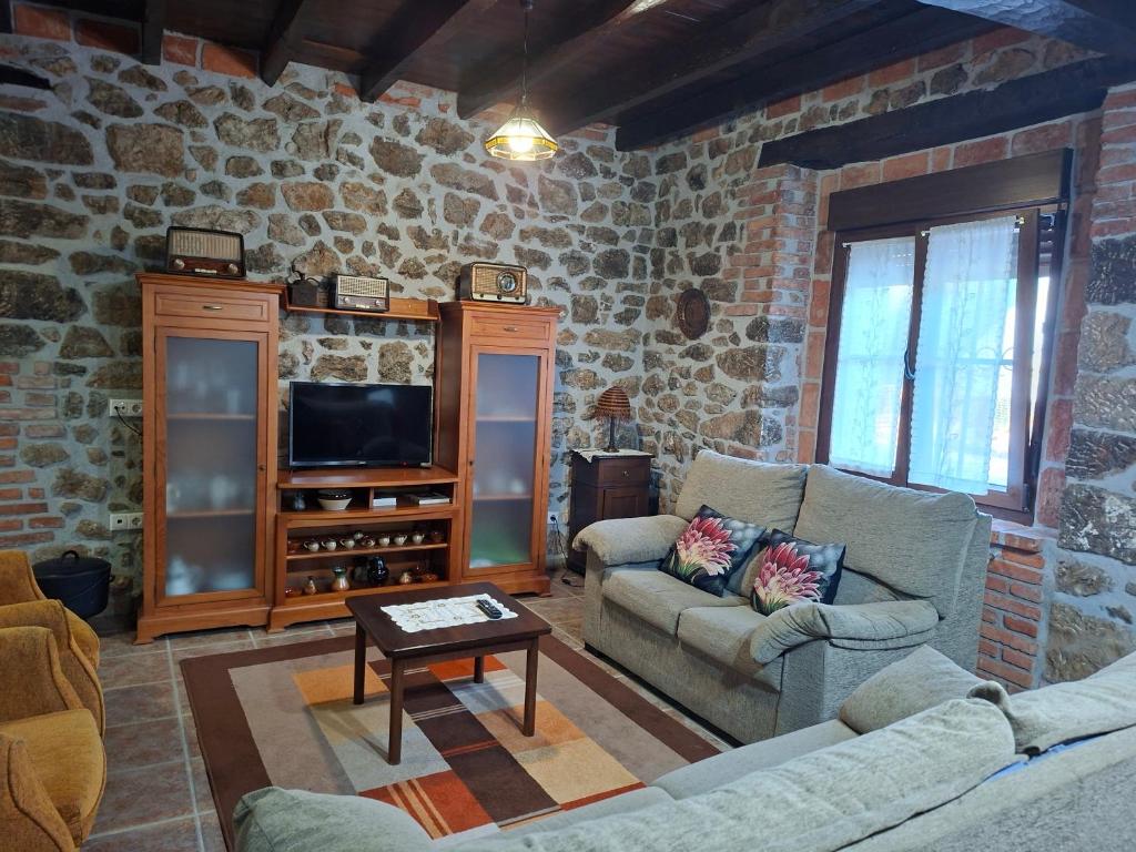 a living room with two couches and a tv at Casa Nardo in Benia de Onís