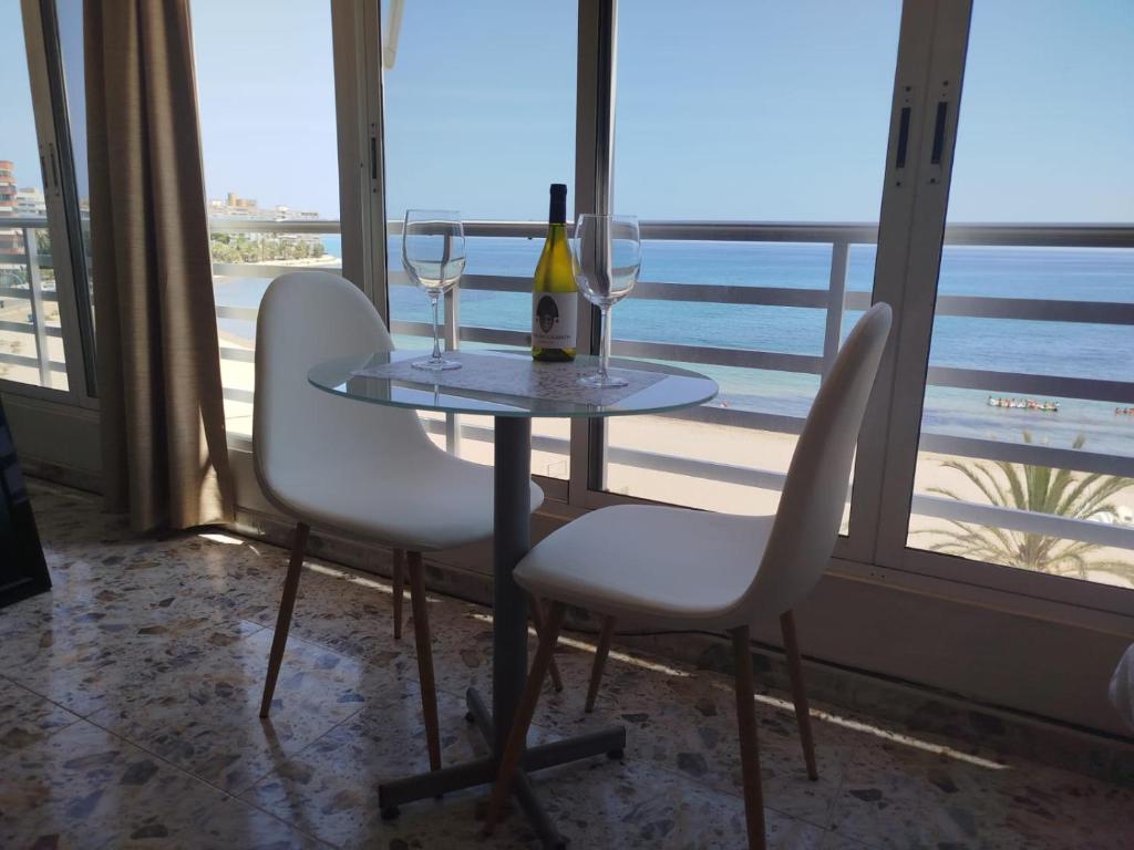 a table with two glasses and a bottle of wine at Campello Muchavista Beach in El Campello
