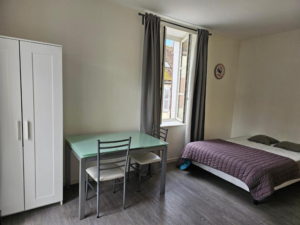 a bedroom with a desk and a bed and a bed and a window at Studio in Bonny-sur-Loire
