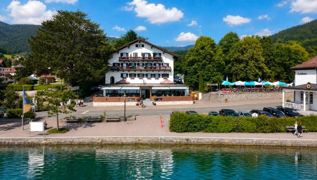 a large white building next to a body of water at Seehotel zur Post in Tegernsee