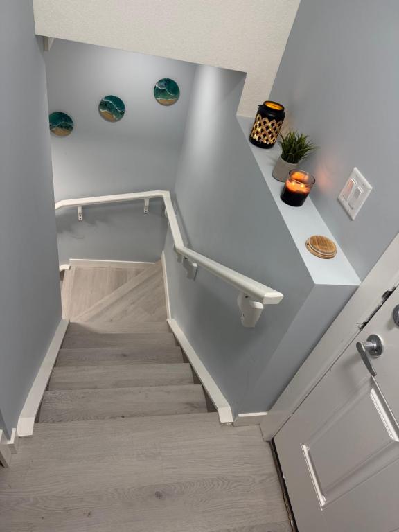 a staircase in a house with white walls and wooden floors at Entire 2BR Suite 12 min to Airport in Calgary