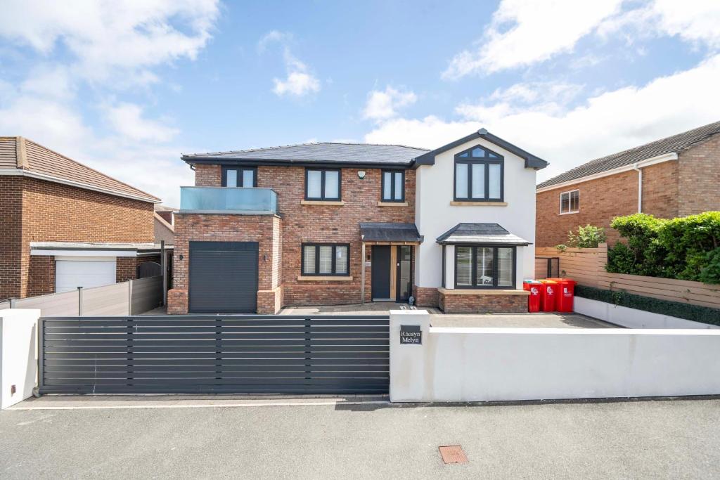 a house with a gate in a driveway at Modern Large 4-Bed Property sleeps 10 in Abergele in Abergele