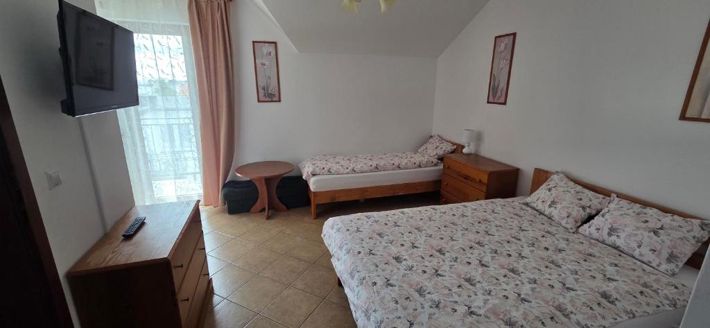 a bedroom with a bed and a table and a tv at Kapitan Hook in Mielno