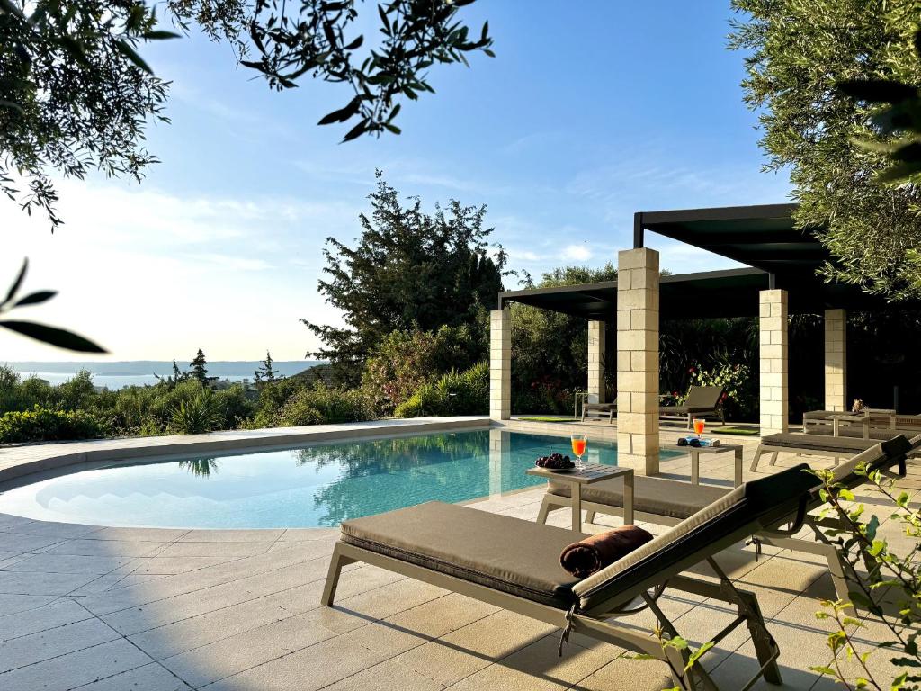 a swimming pool with a chaise lounge next to at Villa Nynemia Almyrida Crete in Plaka