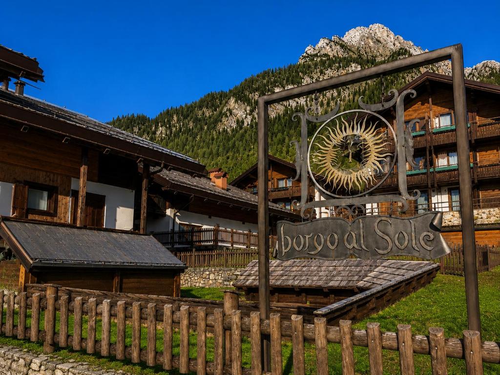 a sign in front of a lodge with a building at Residence Borgo Al Sole in Sappada