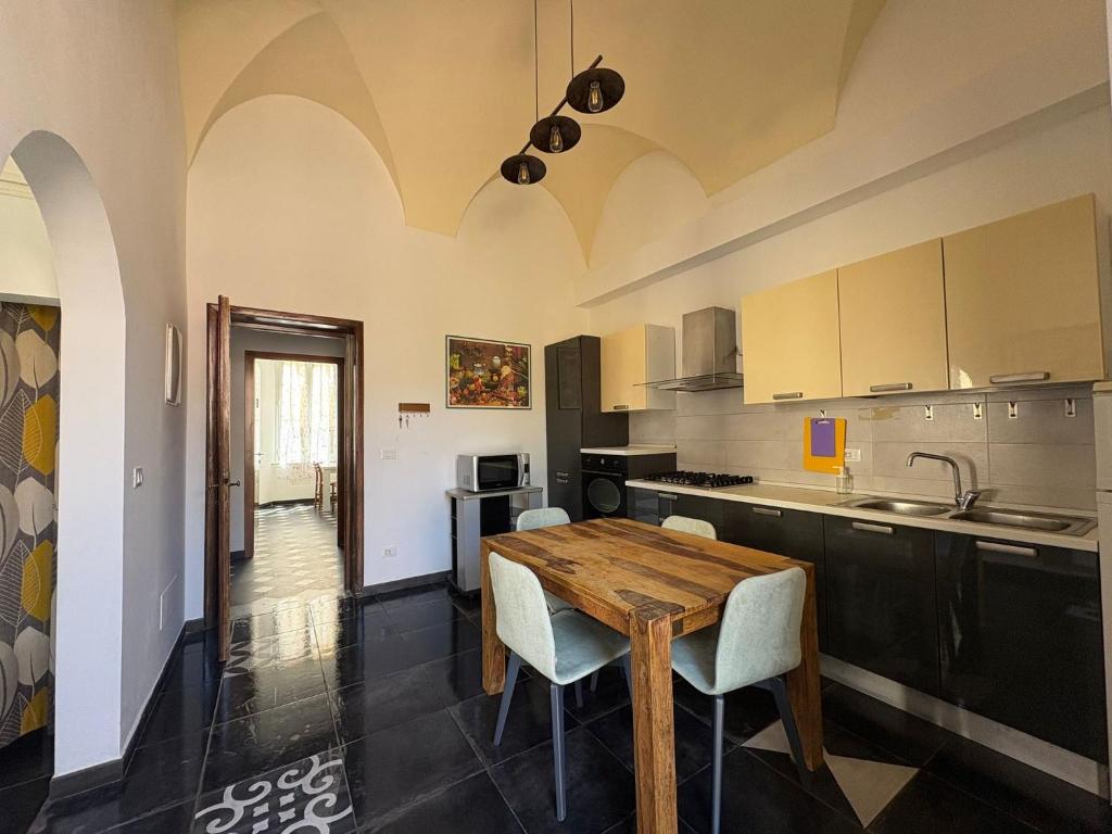 a kitchen with a wooden table and chairs at Riviera Blu Rooms in Laigueglia