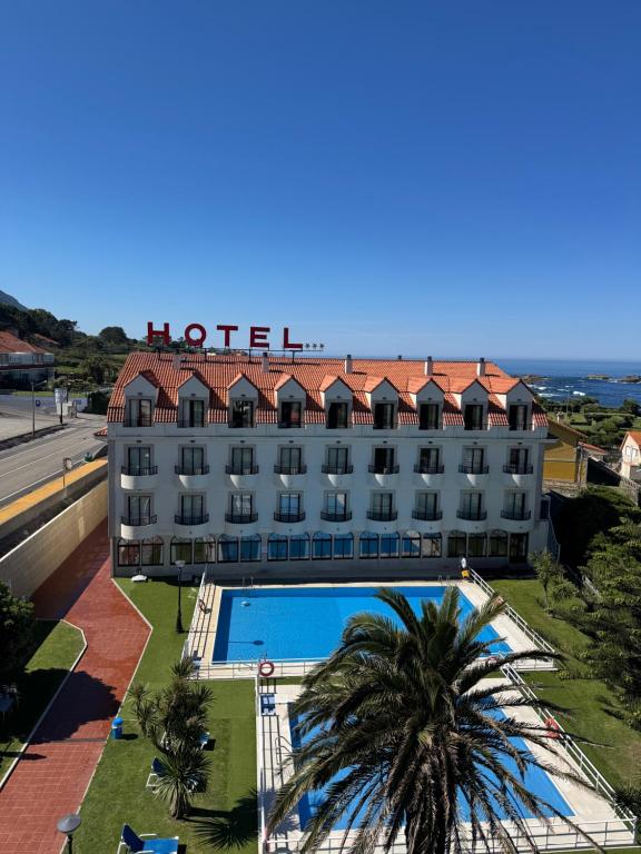 a hotel with a swimming pool and a building at Hotel Restaurante Glasgow in Villadesuso