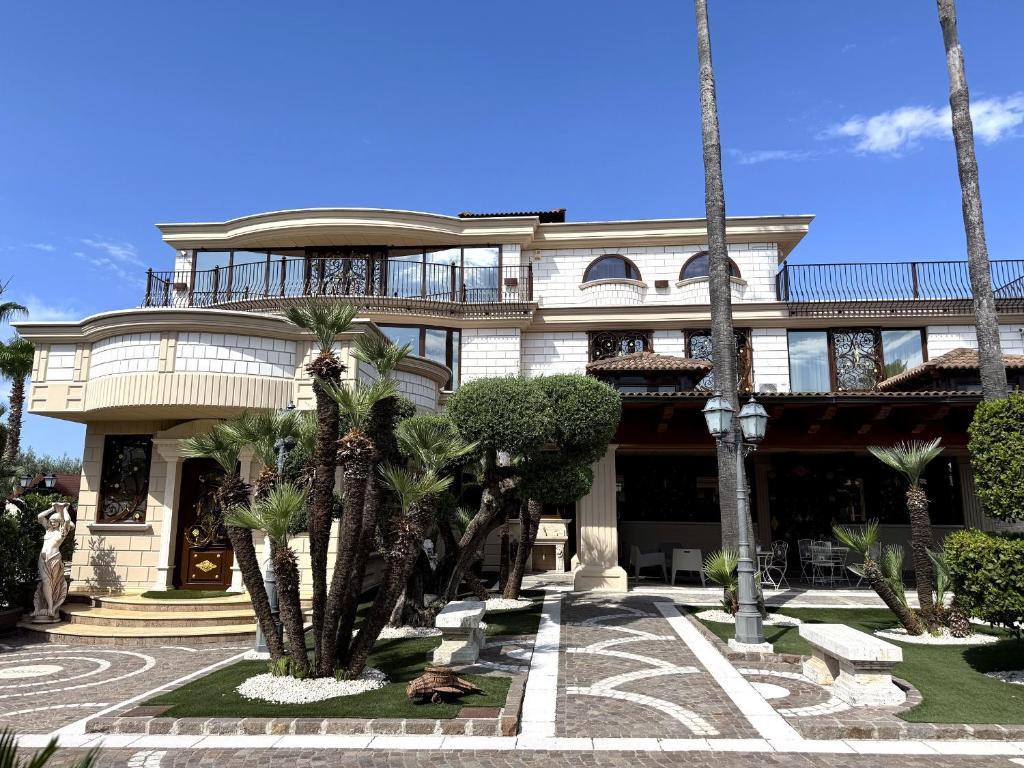a large building with palm trees in front of it at Le Tre Rose di Metta in Cerignola