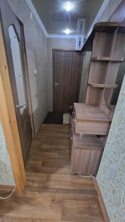 a staircase in a room with a wooden stair case at Квартира1 in Balqash