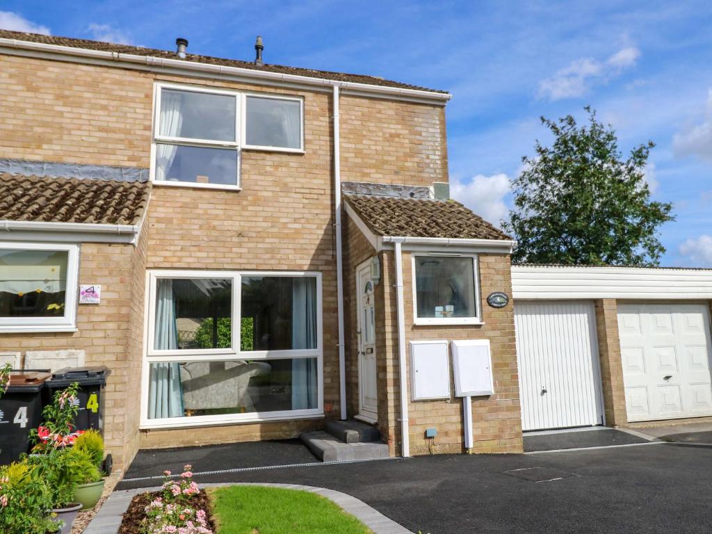 a brick house with a garage at Camellia Cottage in Wimborne Minster