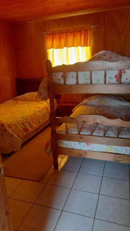 a bedroom with two bunk beds and a window at Camping Las Torcacitas in Yerbas Buenas