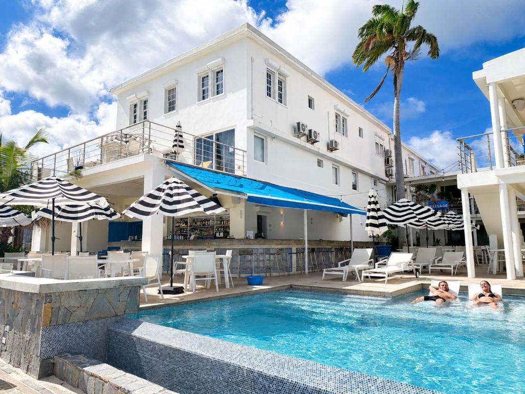 two people in a swimming pool in front of a house at Seaview Beach Hotel in Philipsburg