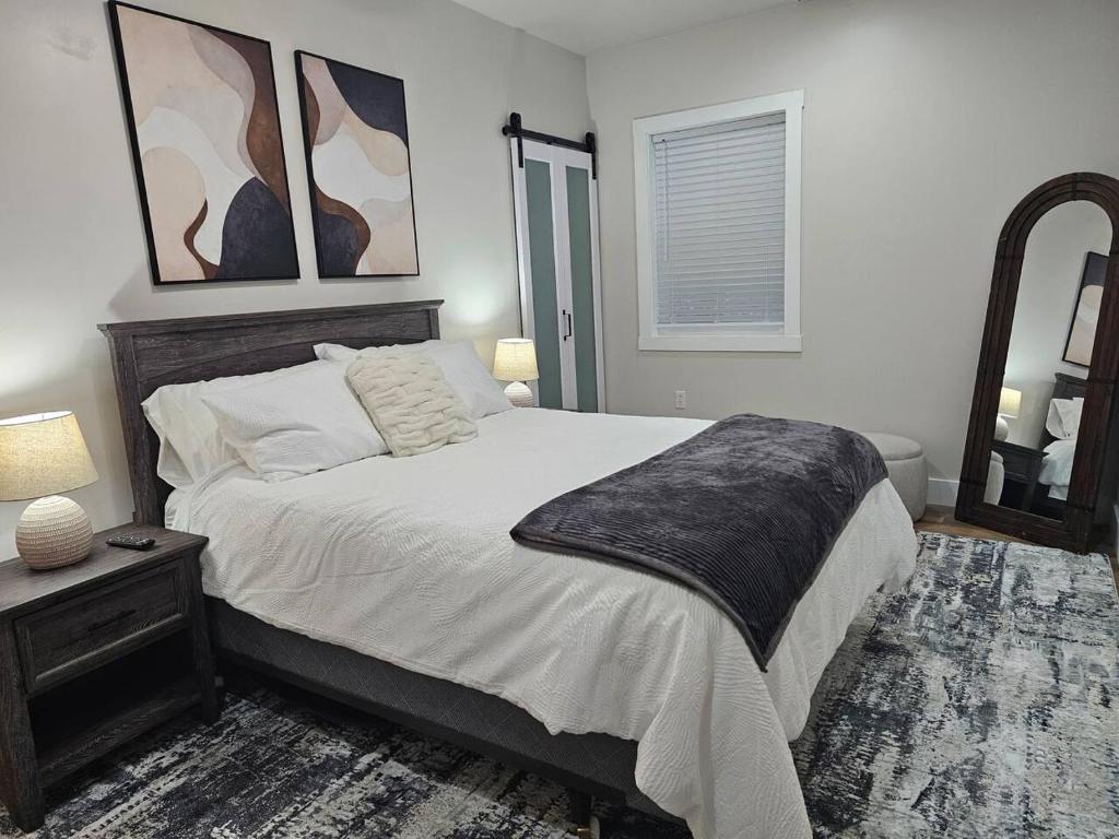 a bedroom with a large bed and a mirror at Nest in the City in Fort Mill