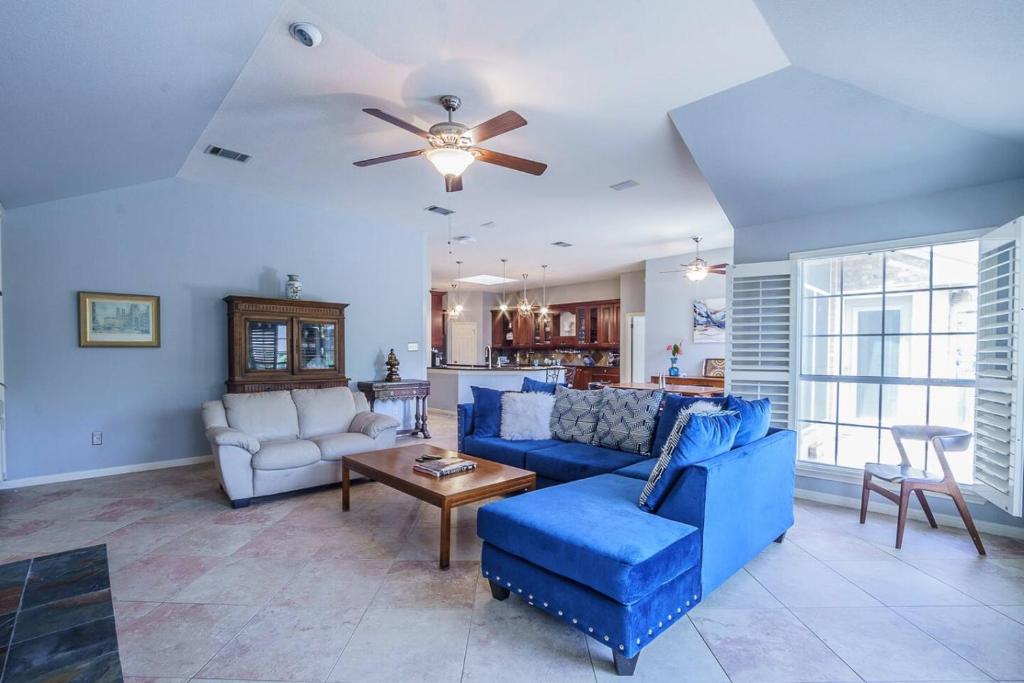 a living room with a blue couch and a table at 3BR home with private pool 3 mins 2 Riverplace in Austin