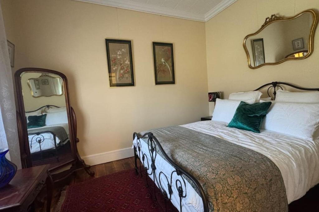 a bedroom with a bed and a large mirror at Oscar's Place in Yass