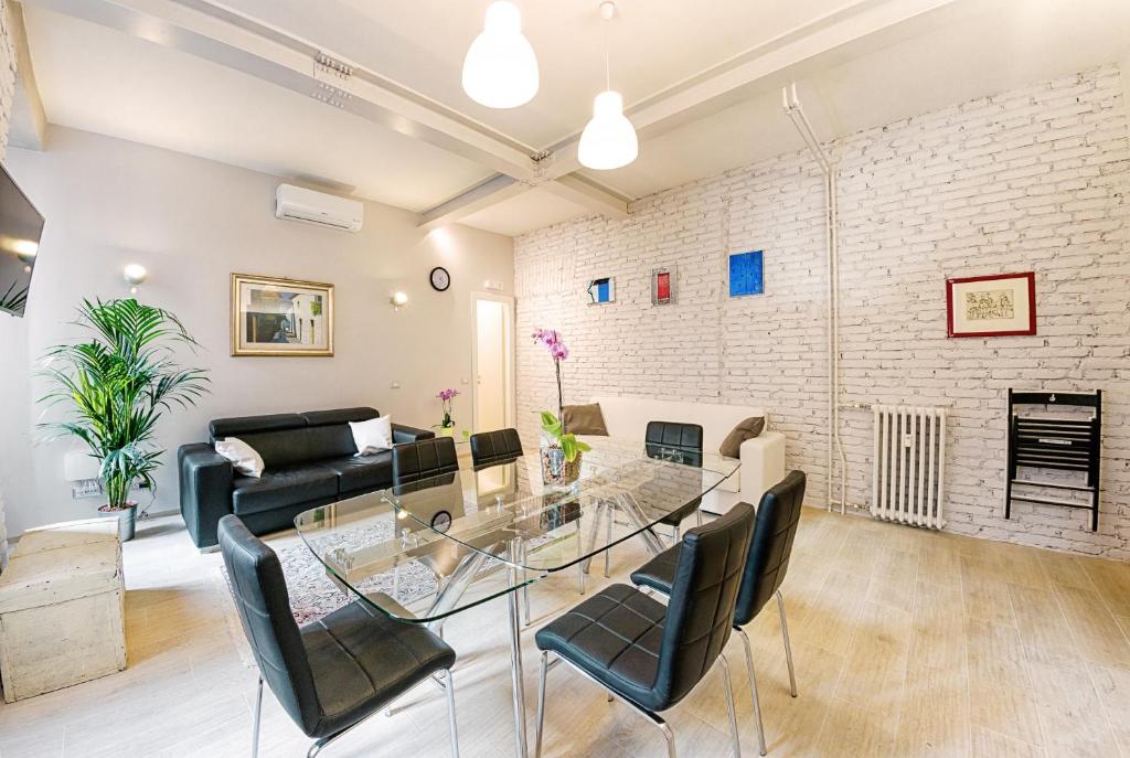 een woonkamer met een glazen tafel en stoelen bij Modern Apartment near Colosseum in Rome