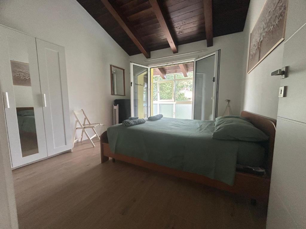 a bedroom with a green bed and a window at Valentinas retreat in San Dorligo della Valle