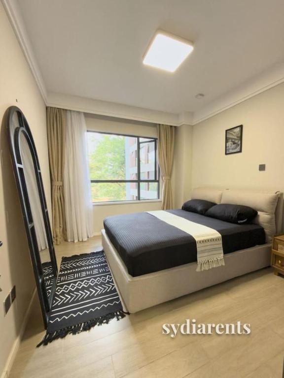 a bedroom with a large bed and a window at Leo Residency in Nairobi