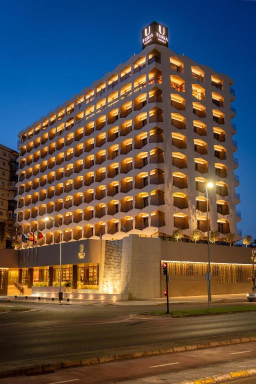 a hotel building with a lit up facade at night at Turia Badajoz in Badajoz