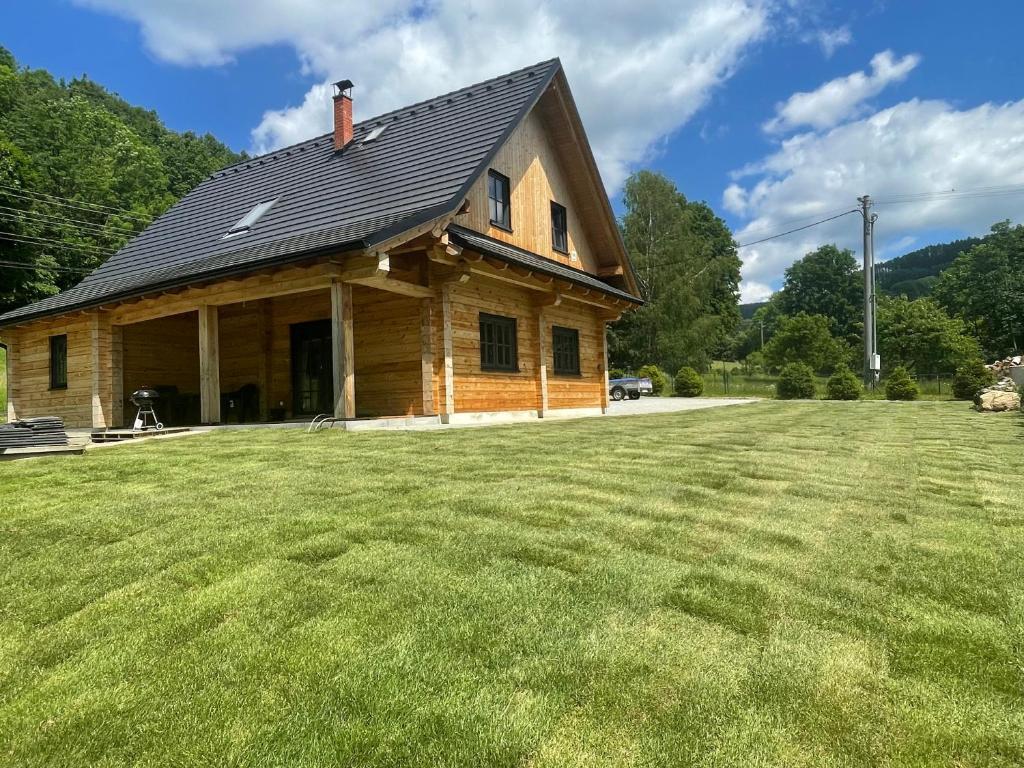 a house with a large grass field in front of it at Chalupa Jesenka in Sobotín
