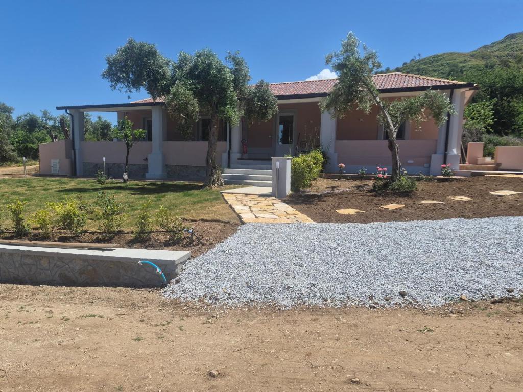 a house with a yard with gravel and trees at Terra e Cielo Rooms in Parghelia