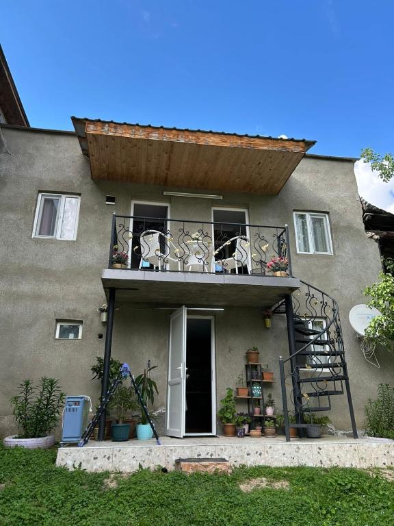 a house with a balcony with a stairway leading up to it at LeriMari in Mestia