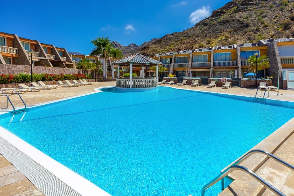 a swimming pool at a resort with a gazebo at Casa Ocean Love Sea View Duplex Tauro Golf in Mogán
