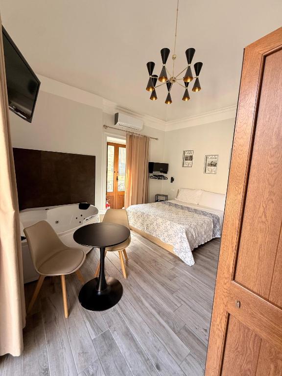 a bedroom with a bed and a table and a chair at Vacanze d'amore in Cefalù