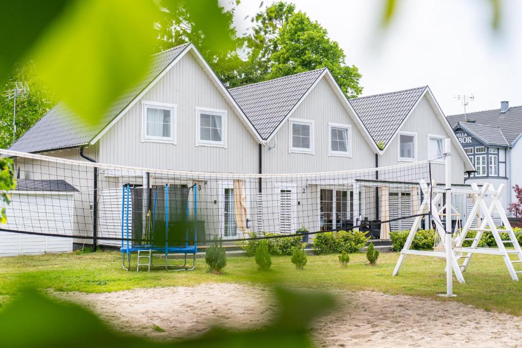 a house with a playground in front of it at Domki Nad Morzem Babki z Piasku Dziwnów in Dziwnów
