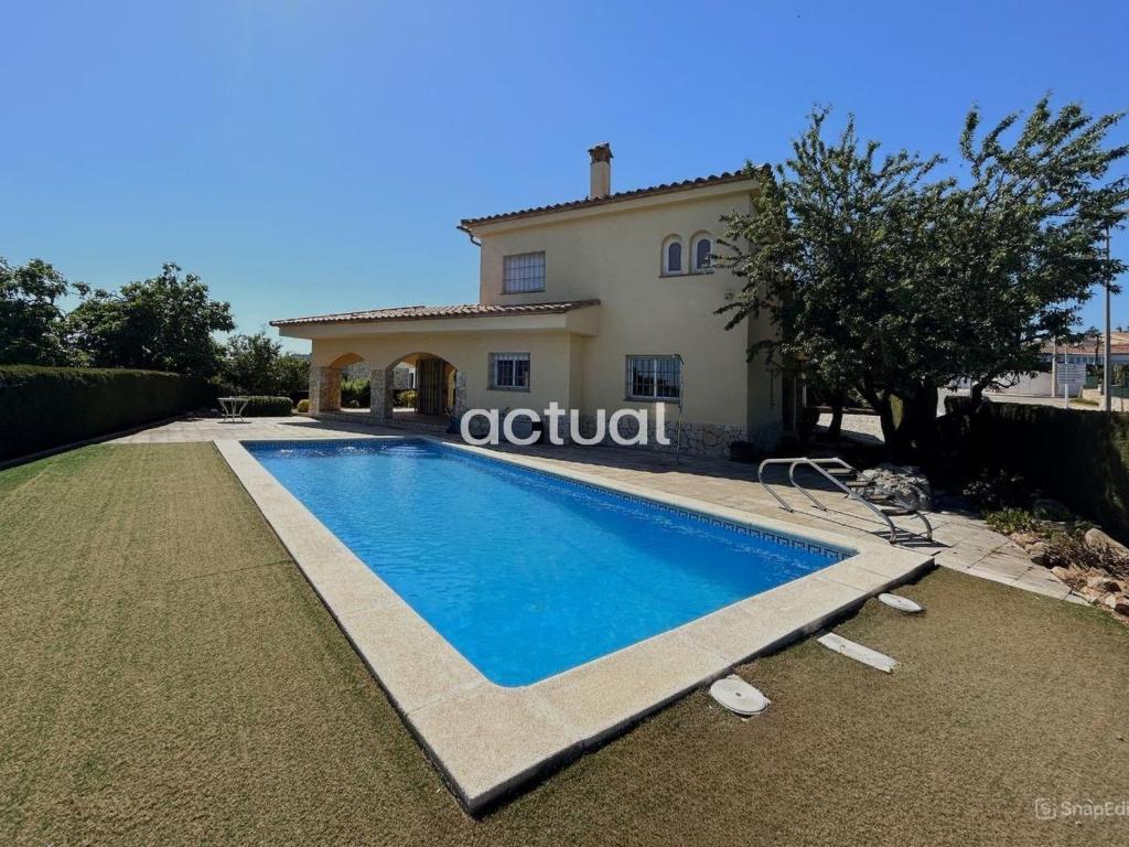 a villa with a swimming pool in front of a house at Casa Torrebosca 43 in Platja d'Aro