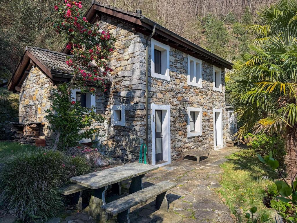 a stone building with a bench in front of it at Rustico Marietta by HolAp SA in Brissago
