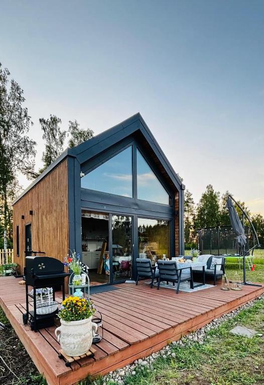 a house with a wooden deck with a living room at Chatka u Radka in Szczodrowo