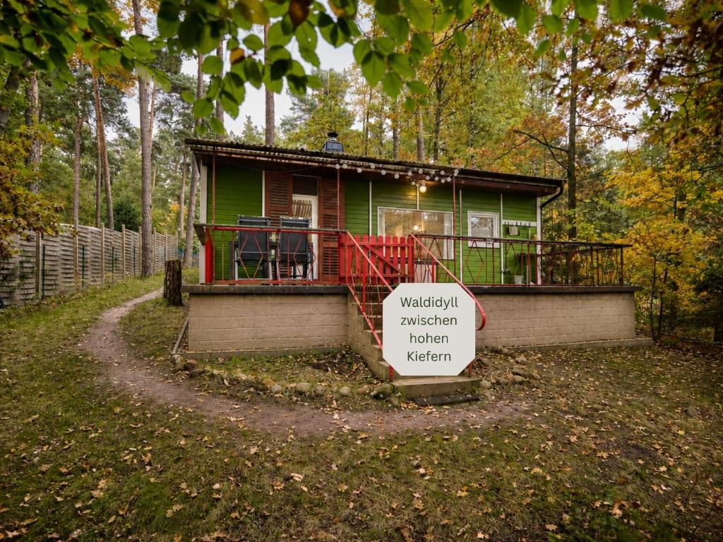 a small green house with a sign in front of it at Waldidyll - Ruhe mitten im Wald in Dahlen