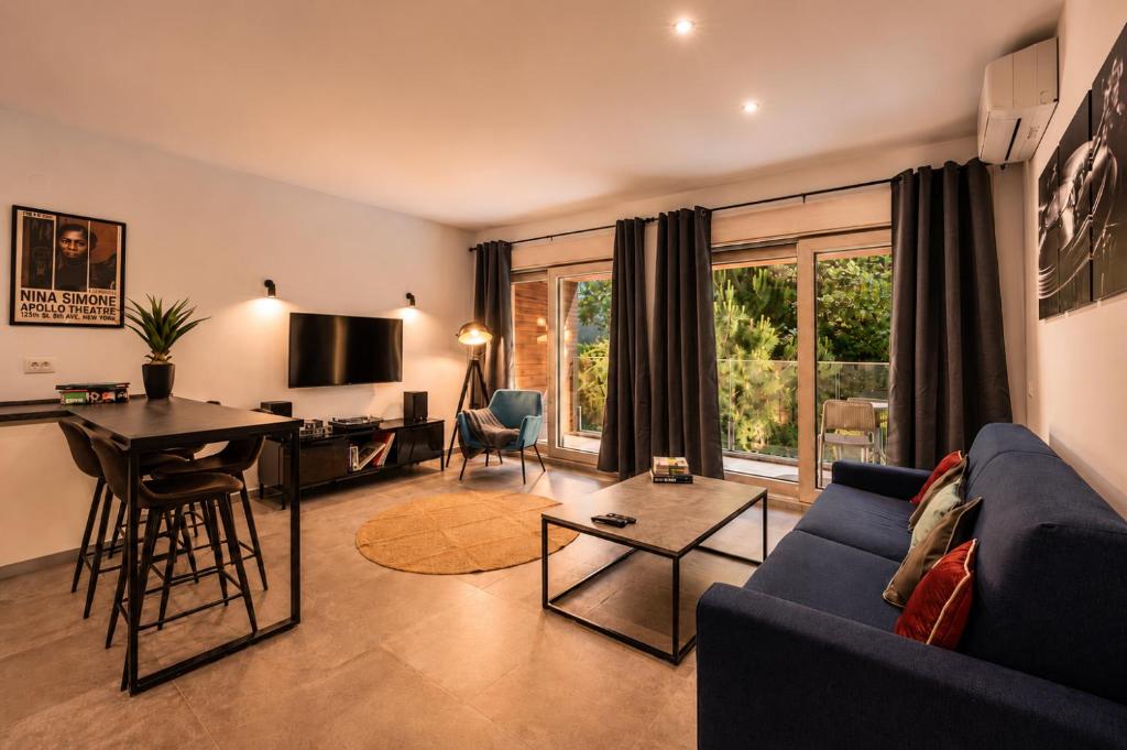 a living room with a blue couch and a table at Vinyl & Wine Retreat by THE HOUSE Experience Collection in Škaljari