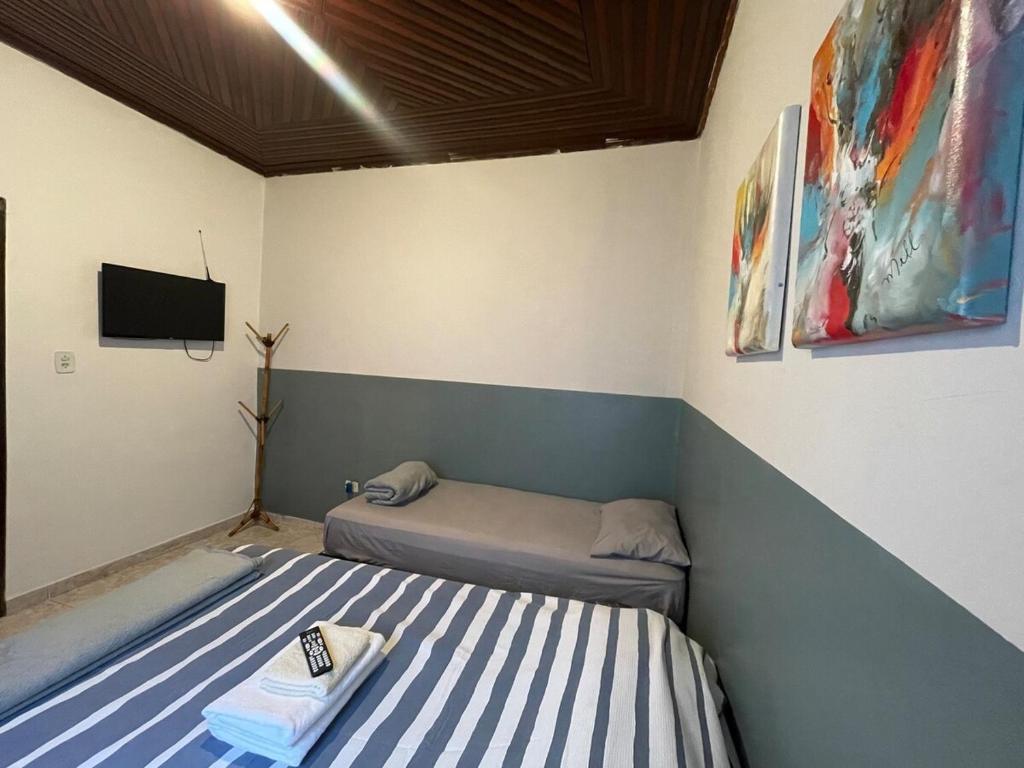 a room with two beds and a tv in it at ACONCHEGO 6 - Self Check-in in Presidente Prudente