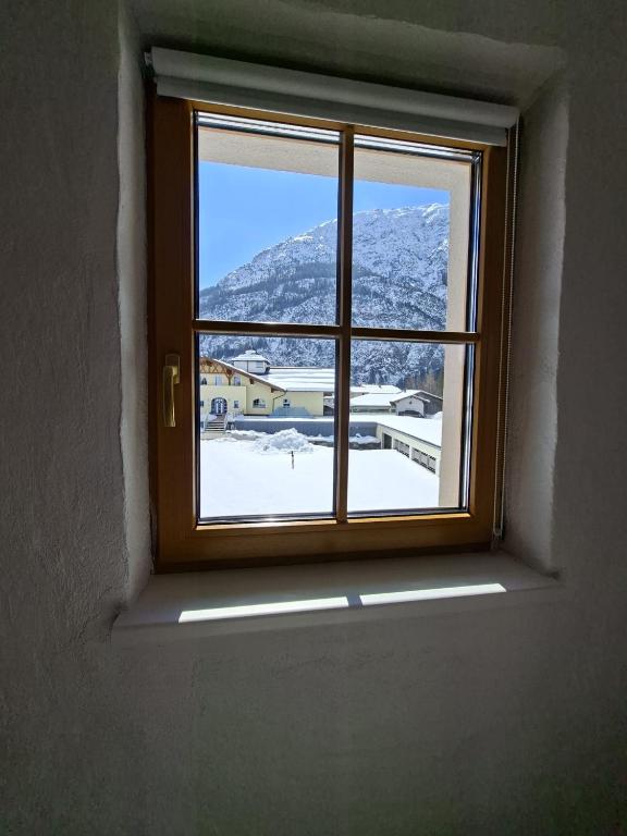 a window with a view of a snowy mountain at Gästehaus Hammerle Holzgau in Holzgau