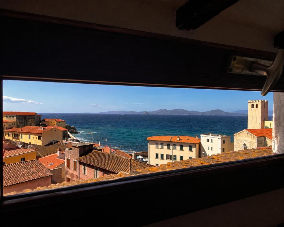 a view from a window of a city and the ocean at Mansarda sopra i canali in Piombino