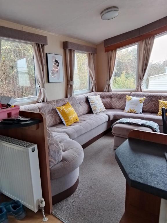 a living room with a couch and some windows at Stay 6 - Pool - Parking - BeachSide - Pet Friendly in Trimingham