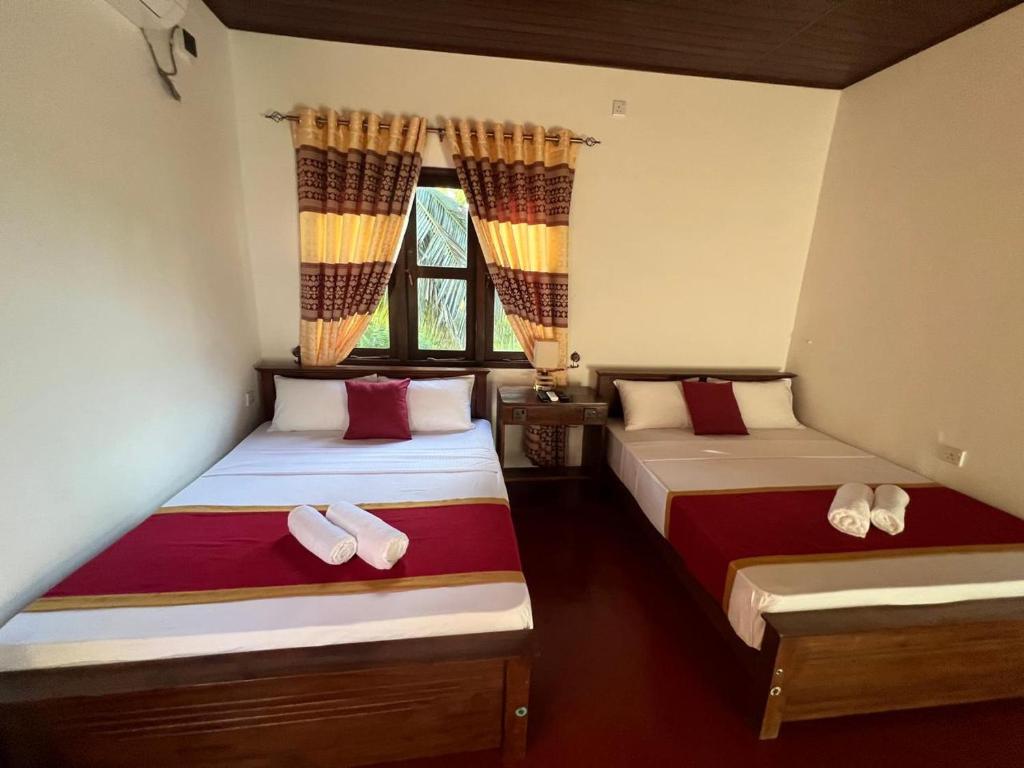 two beds in a room with slippers on them at The Red Loft Mihinthale in Anuradhapura