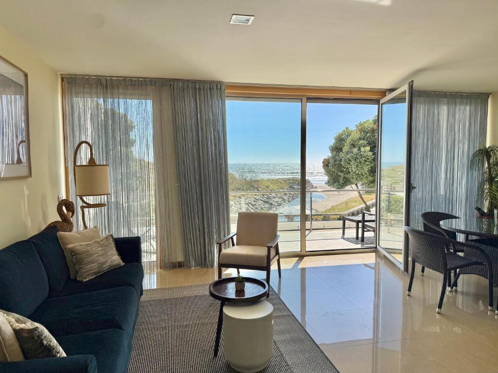 a living room with a view of the ocean at Sol Poente Praia Apartment in Apúlia
