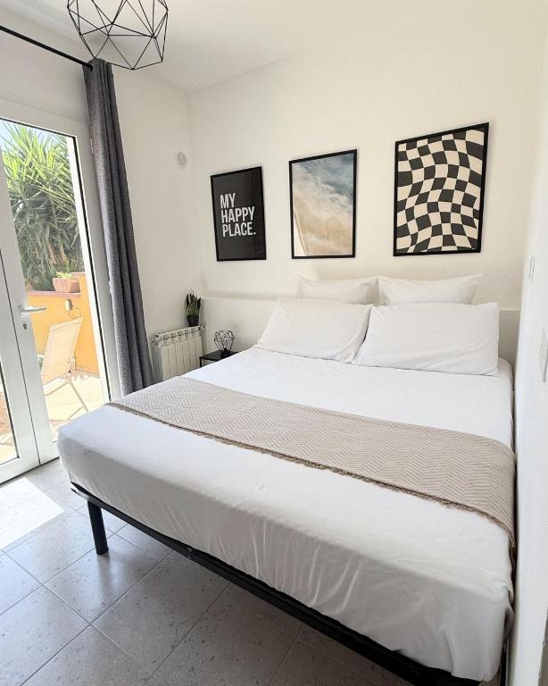 a bedroom with a large bed and a balcony at Maya Apartments in La Maddalena