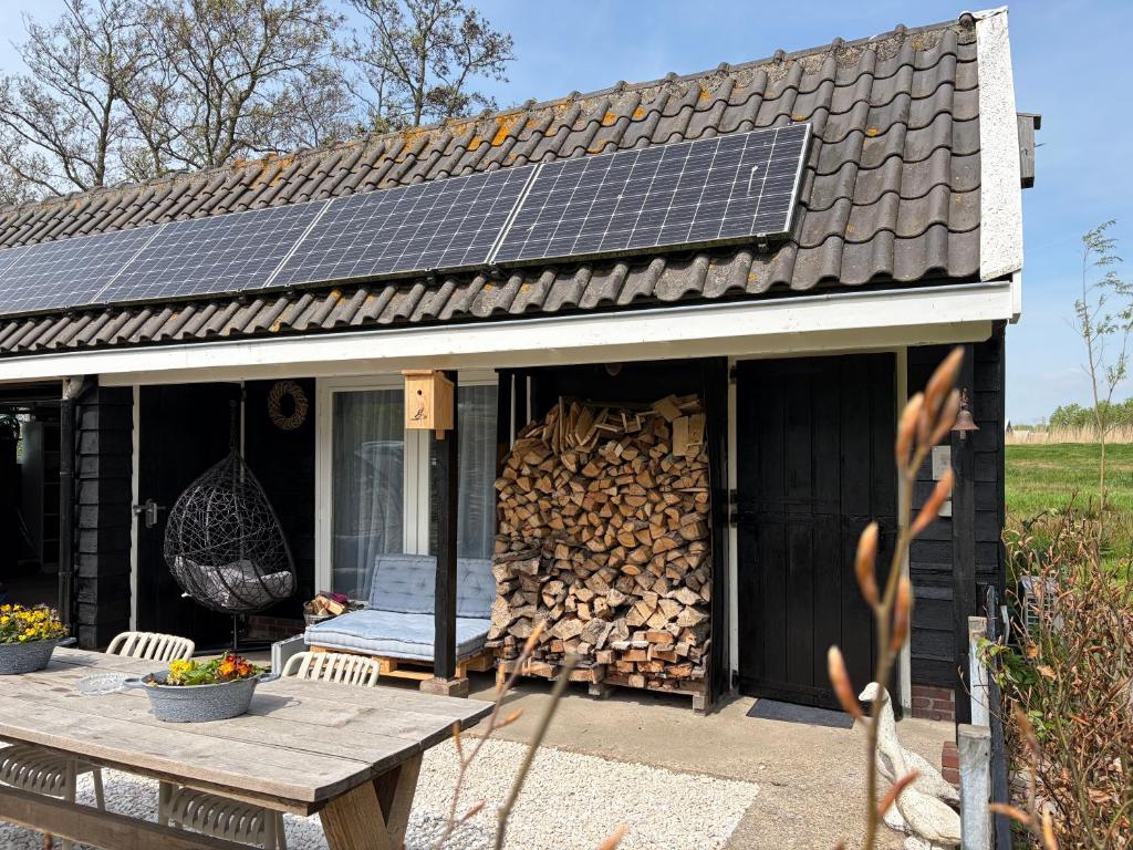 a building with a pile of fire wood and a table at 'T Dijkhuisje - Driehuizen in Driehuizen