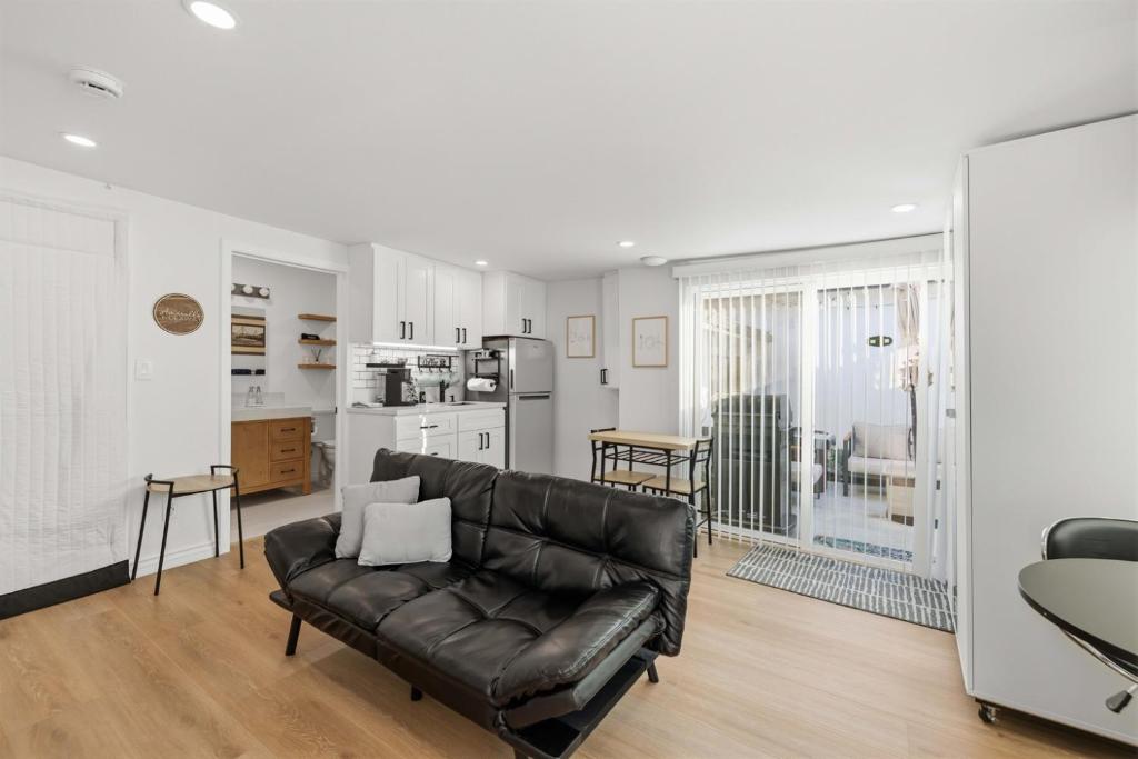a living room with a leather couch and a kitchen at Newly Renovated 1BR Suite, Patio BBQ, Fire Pit in Simi Valley