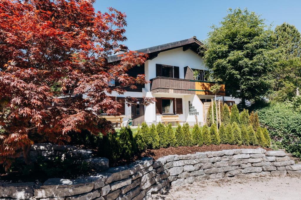 a house with a stone wall and trees at Stoderglück by Alpenidyll Apartments in Gröbming
