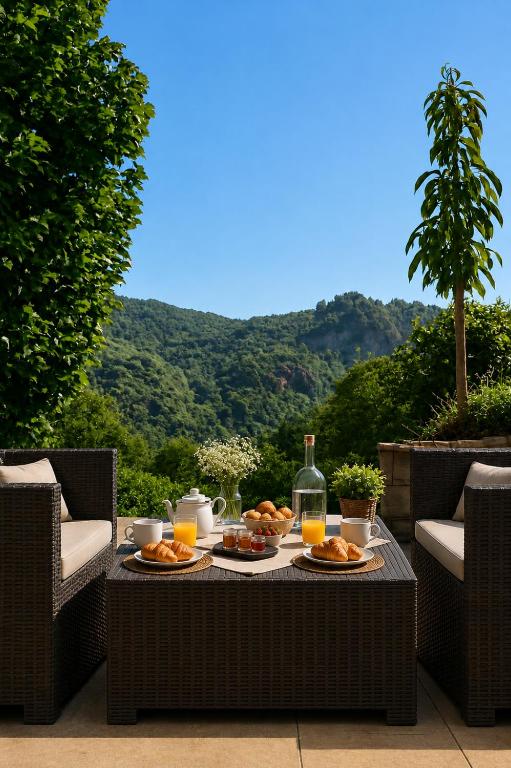 a table with plates of food and a bottle of wine at Le Refuge de la Tour entre mer et ciel in Porri