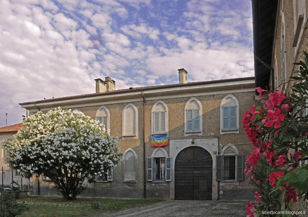 a large brick building with a door and a tree at Casa Berra in Milan