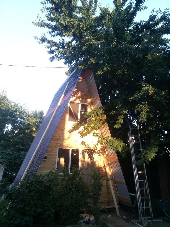 a house with a gambrel roof with a ladder at Ada chalet in Mărăcineni
