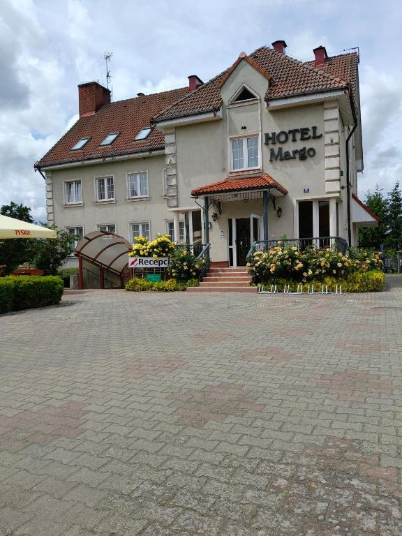 a hotel maker building with a brick parking lot at Hotel Margo in Cedynia