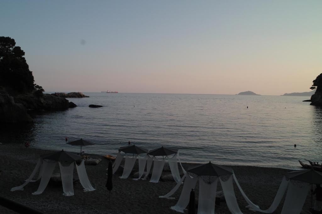 a row of umbrellas on a beach next to the water at Eco del Mare in Lerici
